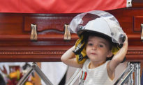 Cha mất vì cứu hoả, con gái nhỏ đội mũ nhận huy chương thay cha trong tang lễ
