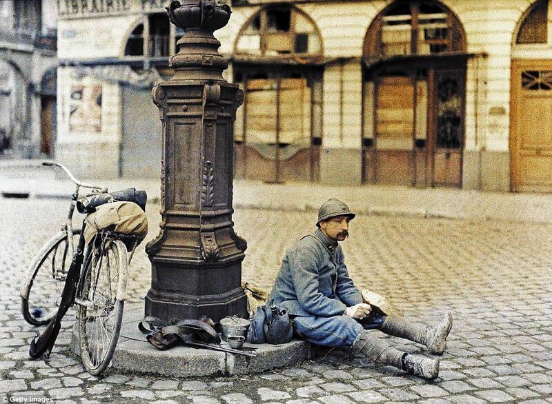 Hình ảnh năm 1917 này cho thấy một người lính Pháp đang ngồi xuống trước một hiệu sách để ăn trưa. Anh ấy rõ ràng đã kiệt sức vì Thế chiến I.