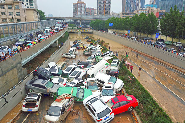 Sau trận lụt ở thành phố Trịnh Châu hôm 22/7, một lượng lớn xe ô tô ngập nước chất đống ngay lối ra phía nam của đường hầm Kinh Quảng ở Trịnh Châu (Ảnh: NOEL CELIS/AFP)