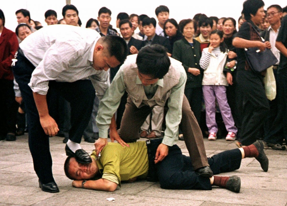 Cảnh sát Trung Quốc bắt giữ một học viên Pháp Luân Công (Pháp Luân Đại Pháp) tại Quảng trường Thiên An Môn ở Bắc Kinh khi một đám đông theo dõi vào ngày 1/10/2000. (Ảnh Chien-min Chung / AP)