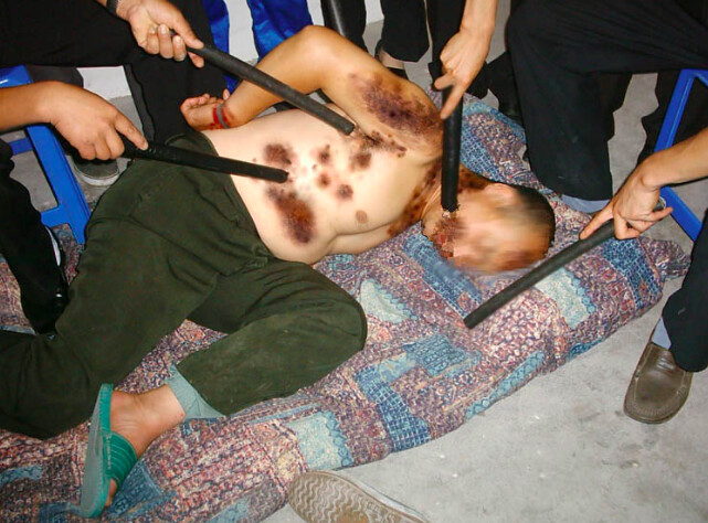 Cảnh tra tấn học viên Pháp Luân Công bị giật điện và đánh bằng roi điện. (Minh Huệ)