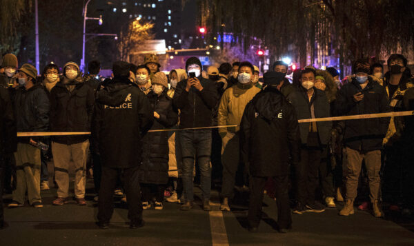 Cảnh sát yêu cầu những người biểu tình đứng phía sau hàng rào trong cuộc biểu tình phản đối các biện pháp phong tỏa nghiêm ngặt để chống dịch của chính quyền Trung Quốc tại Bắc Kinh, Trung Quốc, vào ngày 27 tháng 12 năm 2022. (Ảnh: Kevin Frayer/Getty Images)
